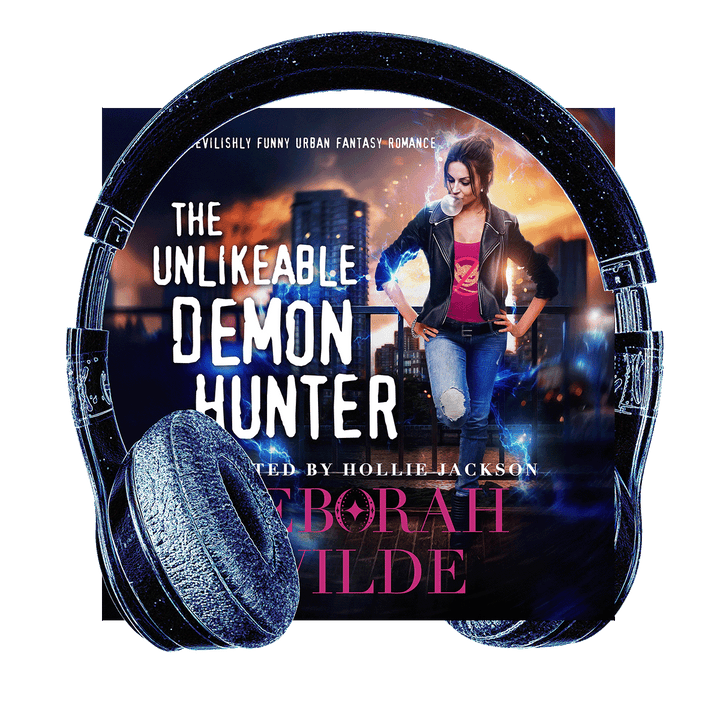 Headphones surround the audiobook cover of "The Unlikeable Demon Hunter" by Deborah Wilde, narrated by Hollie Jackson. A woman blowing bubblegum stands with hands on hips, wearing a red t-shirt with a "no demons" logo.